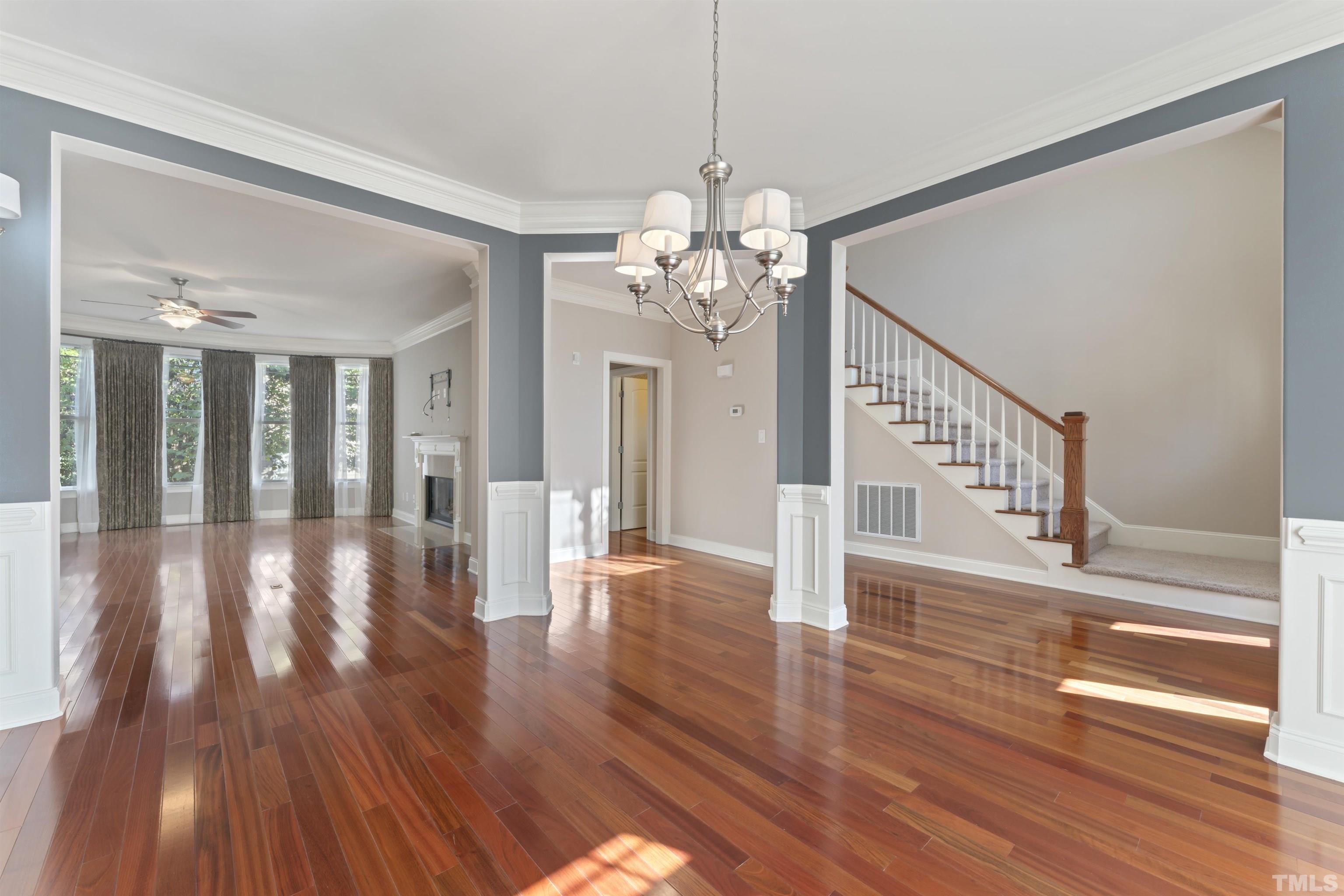 2809 Peachleaf Street Raleigh, NC 27614 - Photo 5 of 18 a view of a hallway with wooden floor and a chandelier