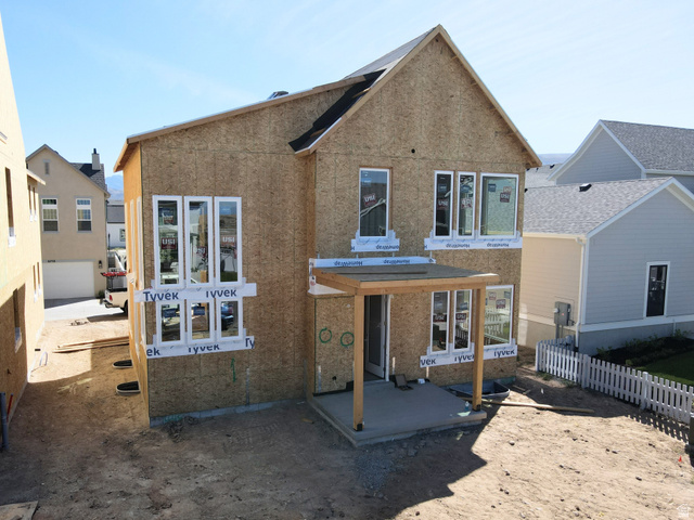 6709 Salt Marsh Road, Unit 448 South Jordan, UT 84009 - Photo 2 of 15 Two-story wood-sheathed structure with multiple windows, a rear patio with a wood pergola, and a partially installed roof