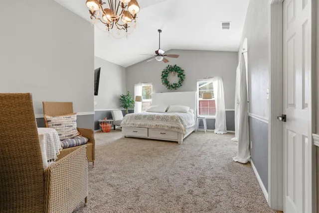a spacious bedroom with a bed and a chandelier