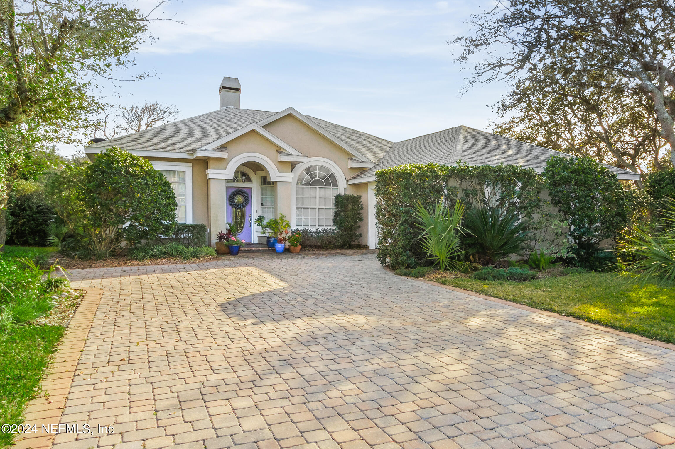 a front view of a house with a yard and trees