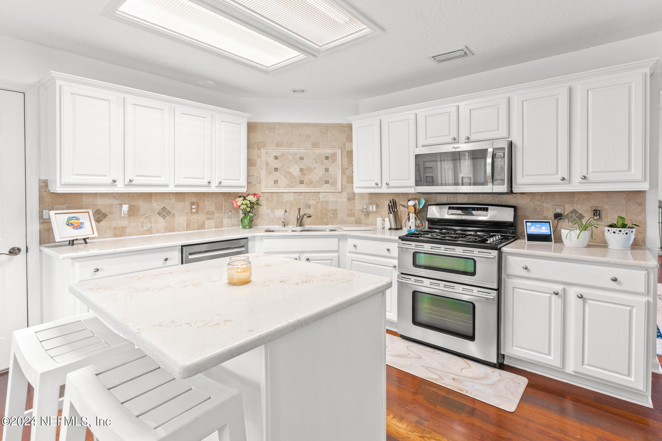 137 South Beach Drive St. Augustine, FL 32084 - Photo 16 of 41 a kitchen with stainless steel appliances granite countertop a sink and dishwasher a stove top oven with white cabinets