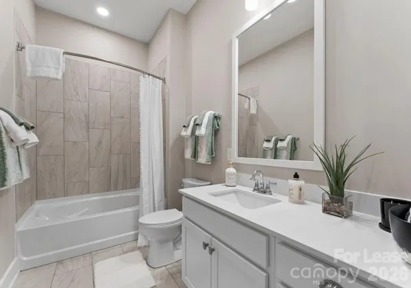 a bathroom with a granite countertop sink a toilet and a bathtub