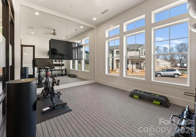 a view of a room with gym equipment and a flat screen tv