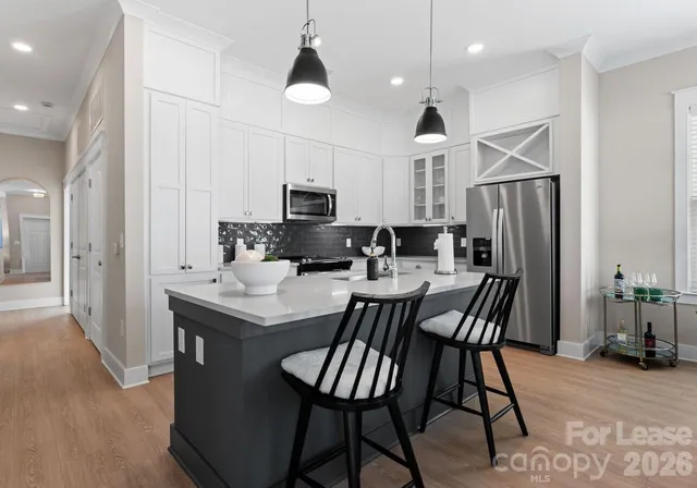 a kitchen with a table chairs refrigerator and microwave