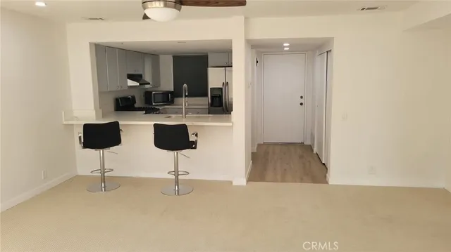 a view of a livingroom with a chair and a refrigerator