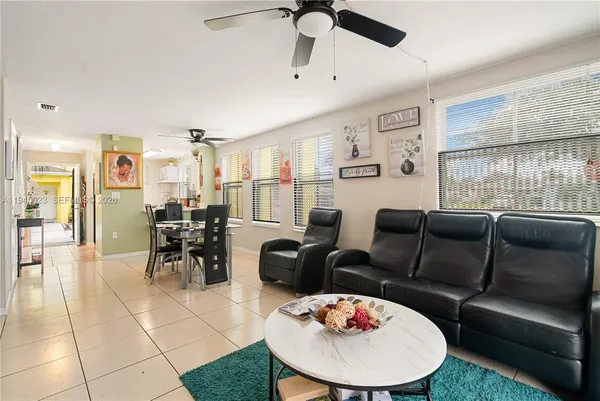 a living room with furniture a dining table and a chandelier
