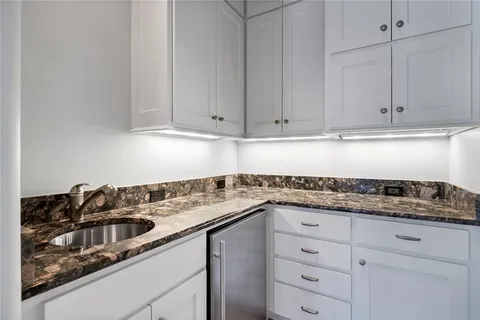 a kitchen with granite countertop white cabinets and white appliances