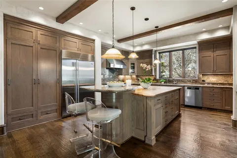 a kitchen with stainless steel appliances granite countertop a sink a stove and a refrigerator