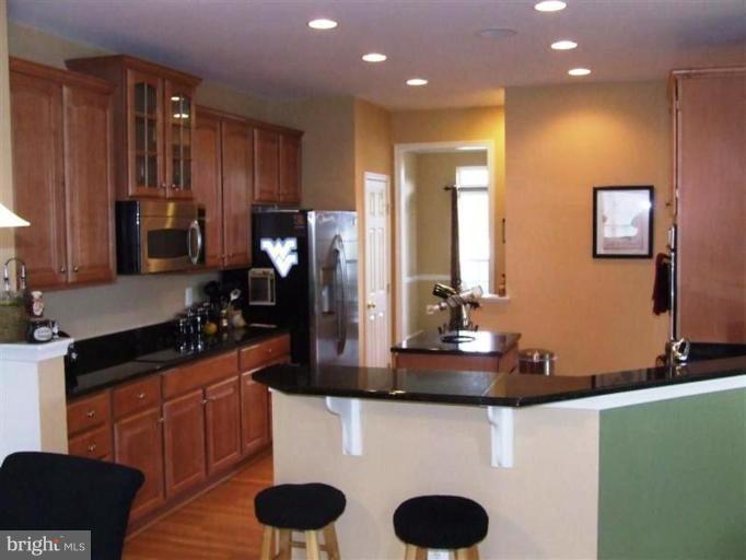 1307 Stallion Street Ranson, WV 25438 - Photo 2 of 22 a kitchen with wooden cabinets and a sink