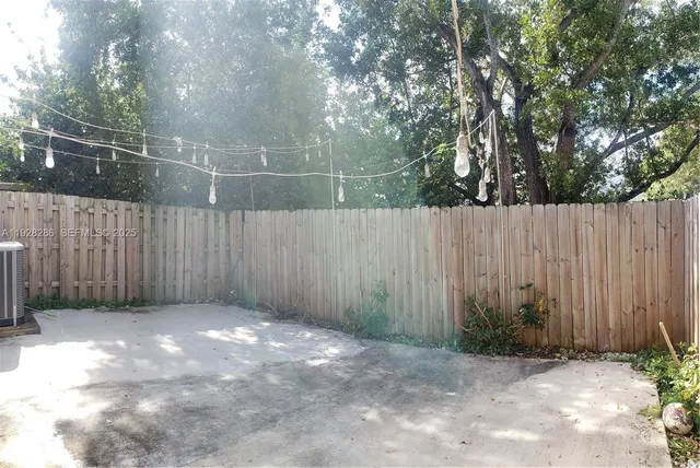 a living room with furniture and a view of kitchen