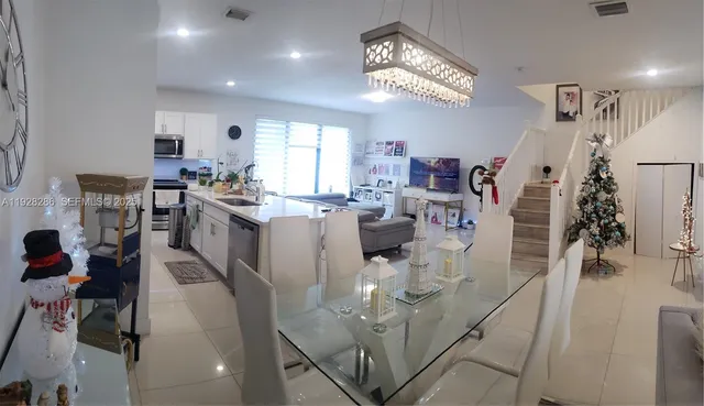 a kitchen with a refrigerator a stove a microwave and a dining table with wooden floor