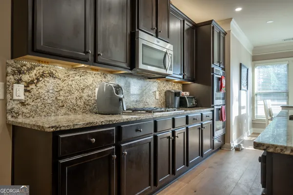 a kitchen with stainless steel appliances granite countertop a sink stove and cabinets