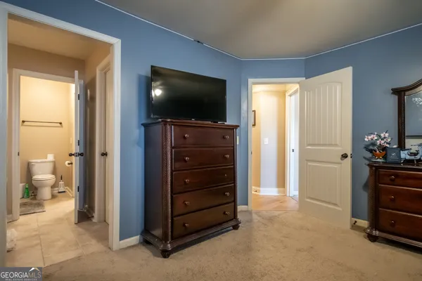 a room with a television and a dresser