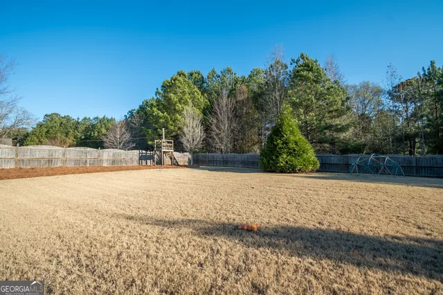 a view of a field with trees in the background