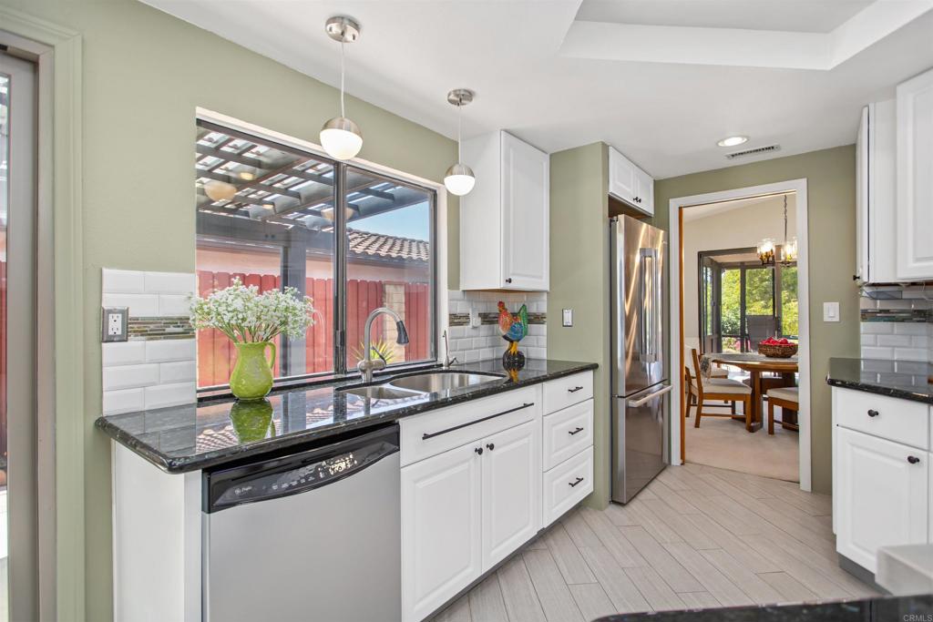 5312 Ontario Street Oceanside, CA 92056 - Photo 14 of 48 a kitchen with stainless steel appliances granite countertop a sink cabinets and wooden floor