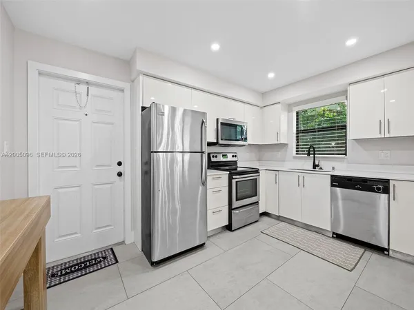 a kitchen with white cabinets and stainless steel appliances