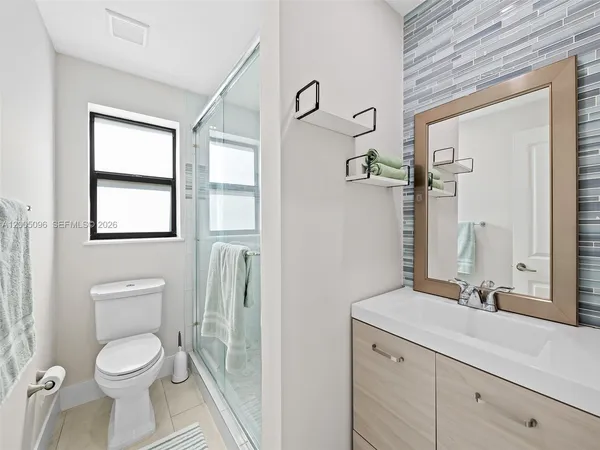a bathroom with a toilet a sink and mirror