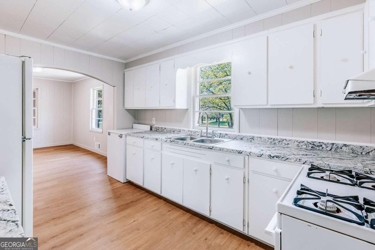 52 Clark Circle Lexington, GA 30648 - Photo 12 of 47 a kitchen with granite countertop white cabinets and white appliances