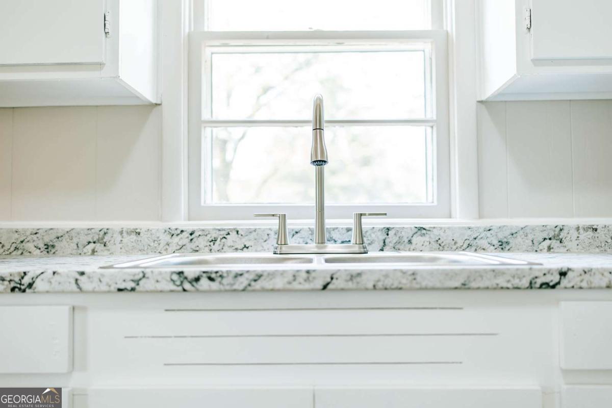 52 Clark Circle Lexington, GA 30648 - Photo 29 of 47 a view of white cabinets with a sink and mirror