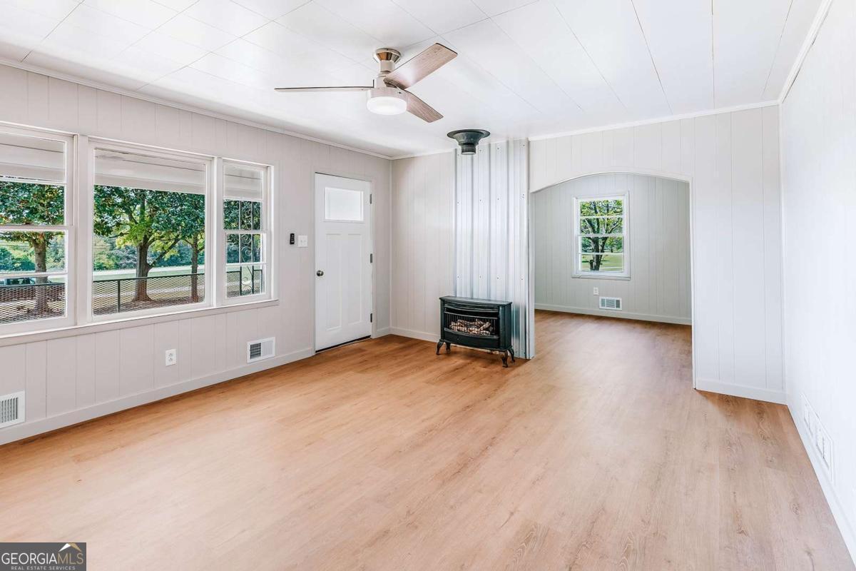 52 Clark Circle Lexington, GA 30648 - Photo 9 of 47 a view of an empty room with a window and wooden floor