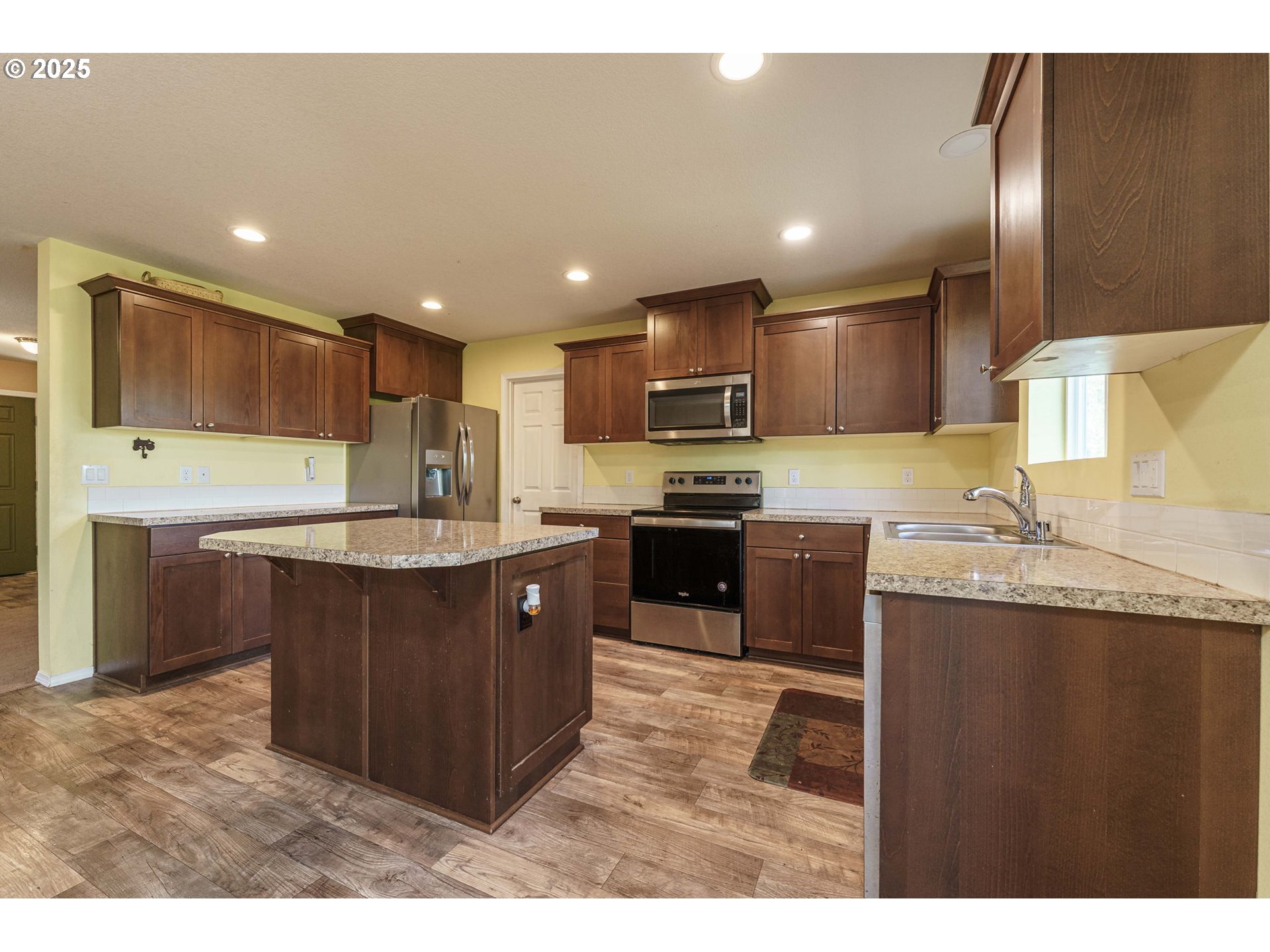 282 Karousel Lane Washougal, WA 98671 - Photo 11 of 42 a kitchen with kitchen island granite countertop wooden cabinets a sink and a stove