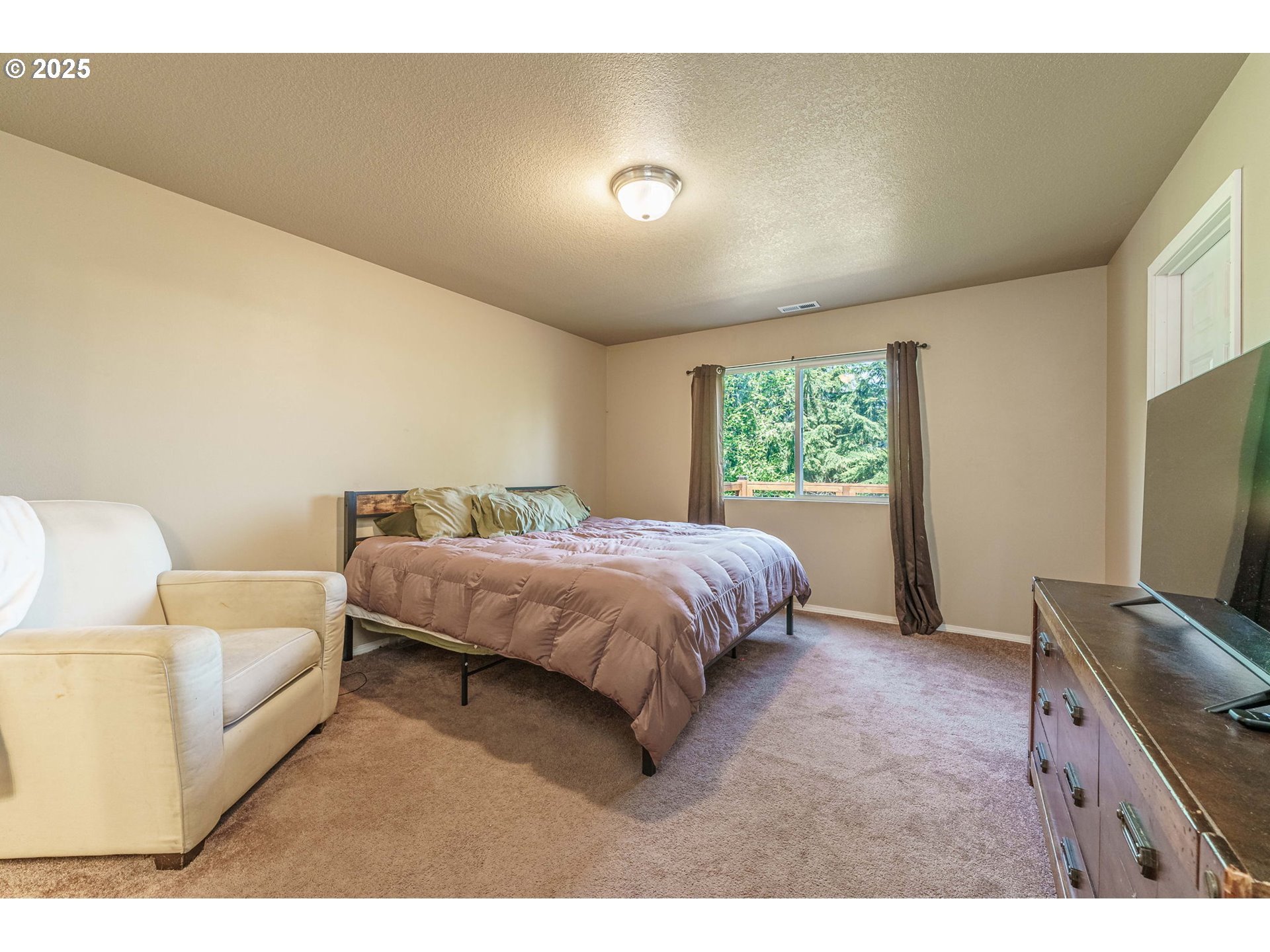 282 Karousel Lane Washougal, WA 98671 - Photo 18 of 42 a spacious bedroom with a bed and a flat screen tv