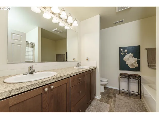 a bathroom with a granite countertop sink a toilet and a mirror