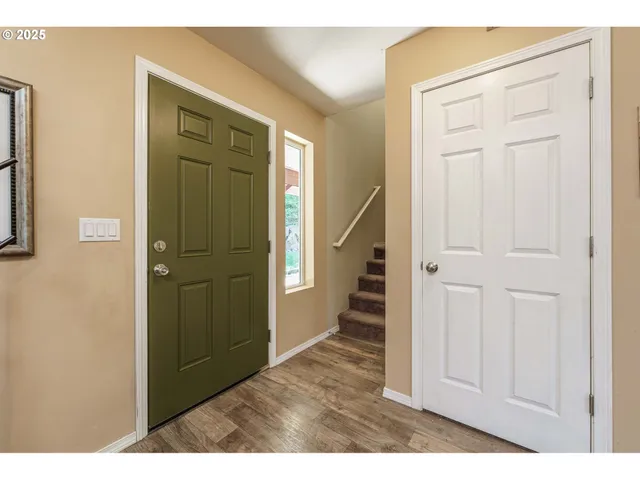 a view of a hallway with wooden floor and staircase