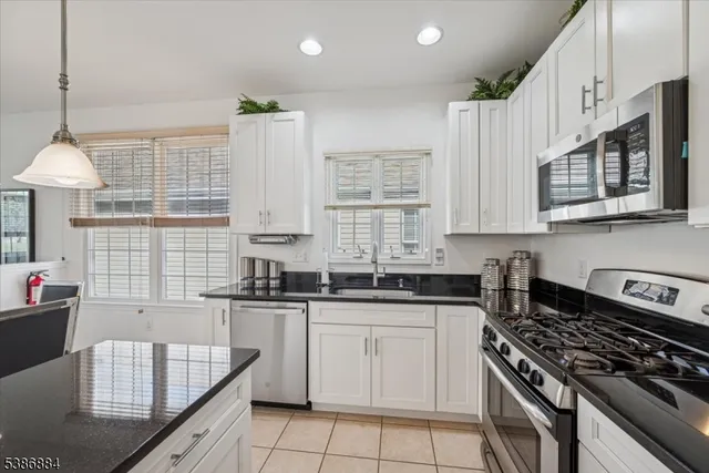 a kitchen with stainless steel appliances granite countertop a stove sink and cabinets