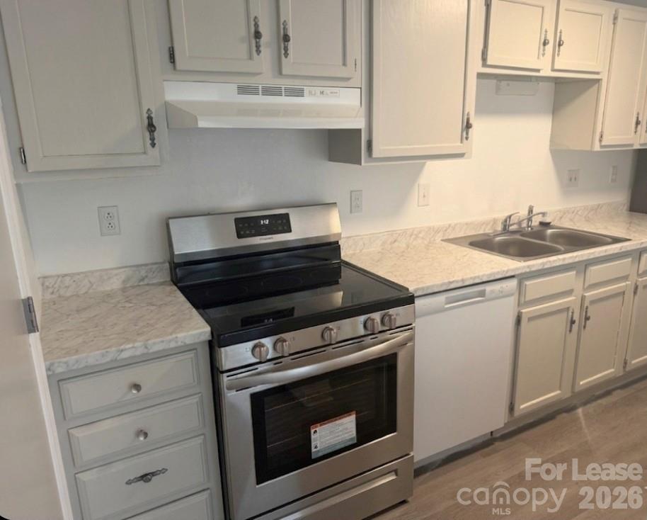 9333 Old Concord Road, Unit J Charlotte, NC 28213 - Photo 2 of 18 a kitchen with granite countertop white cabinets and white appliances