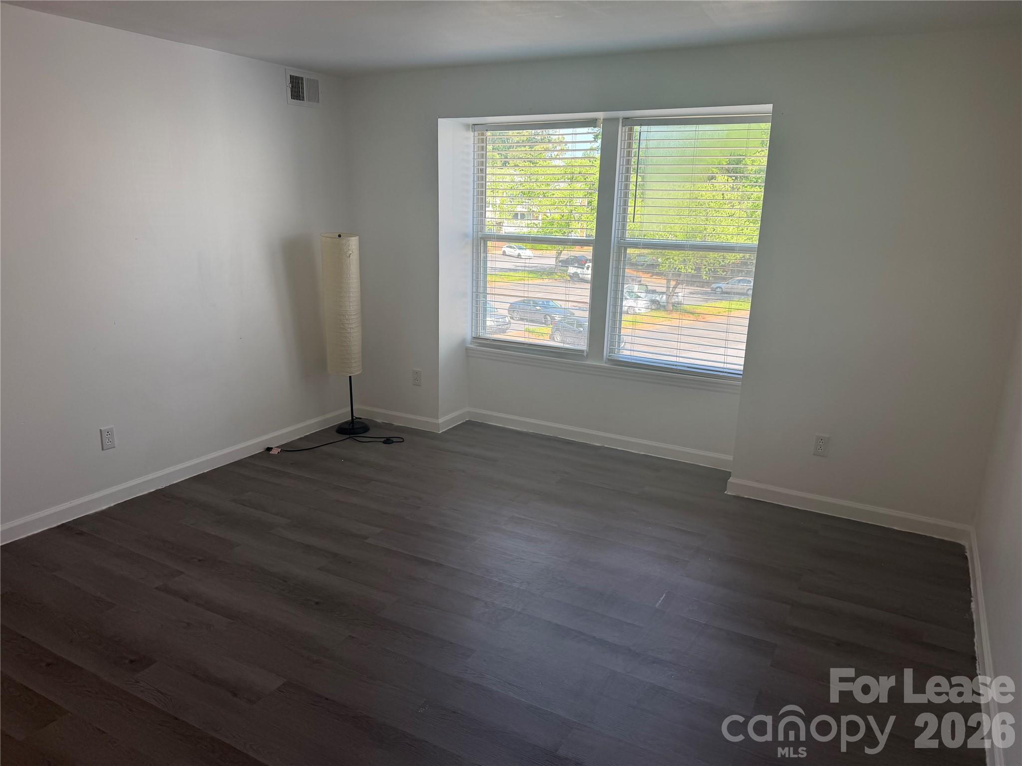 9333 Old Concord Road, Unit J Charlotte, NC 28213 - Photo 9 of 18 an empty room with wooden floor and windows