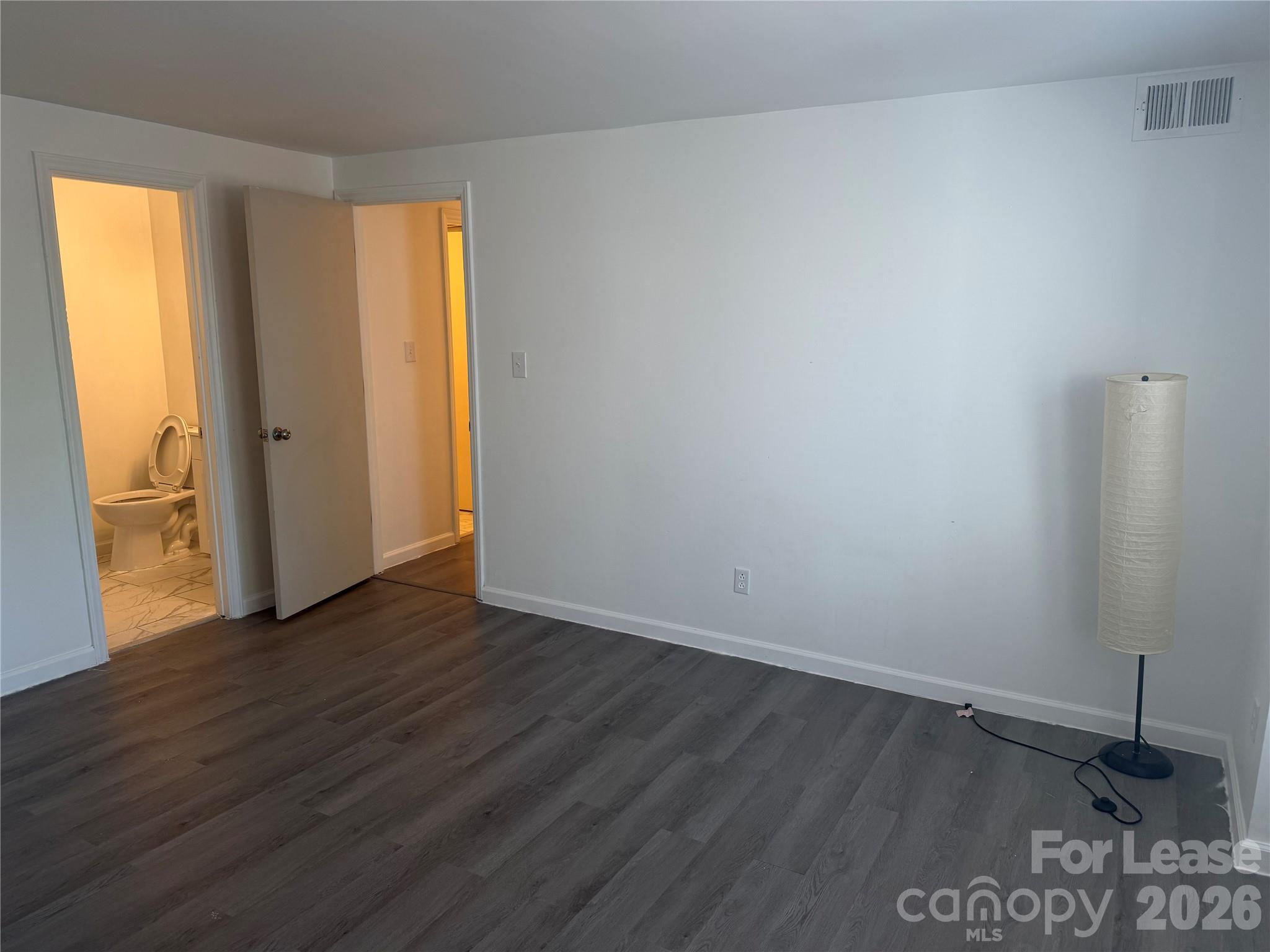 9333 Old Concord Road, Unit J Charlotte, NC 28213 - Photo 10 of 18 a view of an empty room with wooden floor and a window