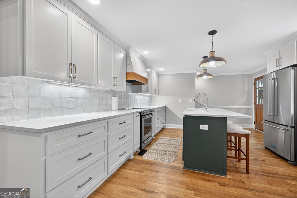 291 Power Point Milledgeville, GA 31061 - Photo 14 of 51 a kitchen with granite countertop a refrigerator a sink dishwasher and white cabinets with wooden floor