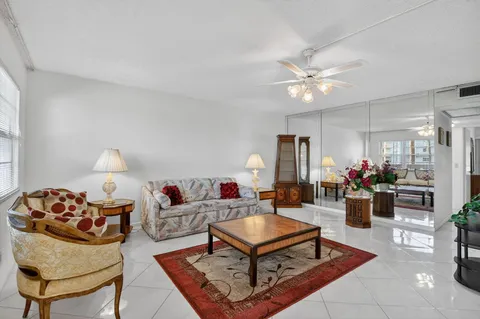 a living room with furniture a chandelier and a rug