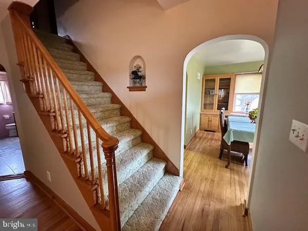 a view of a hallway with wooden floor and stairs