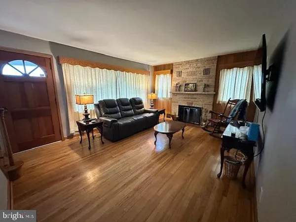 a living room with furniture fireplace and a large window