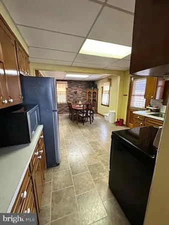 a kitchen with granite countertop a refrigerator and a stove top oven