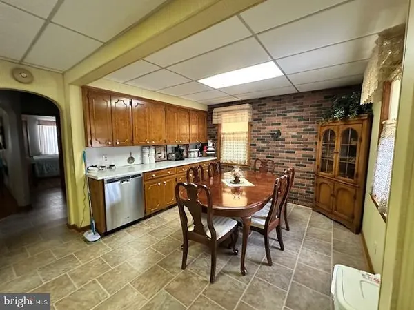 a kitchen with stainless steel appliances kitchen island granite countertop a table chairs and a refrigerator
