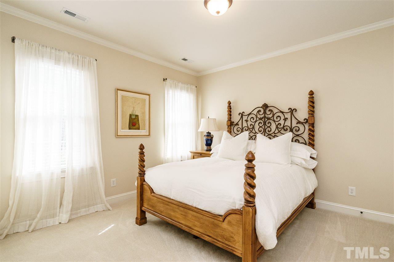 2000 Angelwing Court Raleigh, NC 27613 - Photo 20 of 25 a bed sitting in a spacious bedroom next to a window and a bathroom