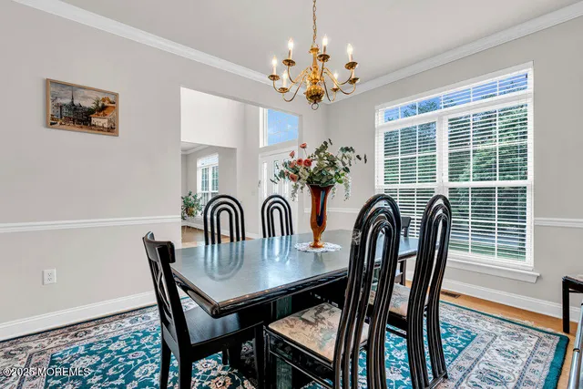 a view of a dining room with furniture a chandelier and wooden floor