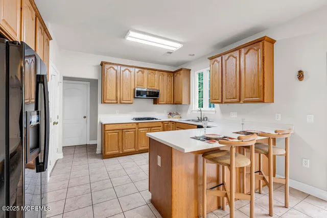 a kitchen with stainless steel appliances granite countertop a stove a sink refrigerator and a microwave