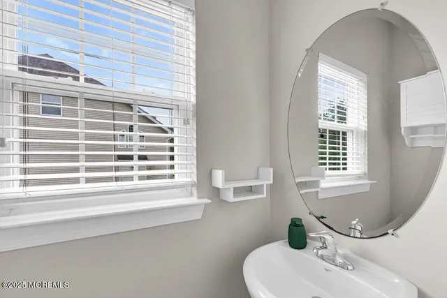 a bathroom with a sink a toilet and a window