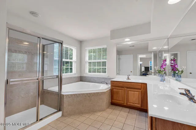 a large spacious bathroom with a tub a sink shower and mirror
