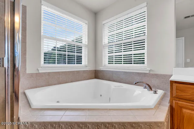 a white bath tub sitting in a bathroom next to a window