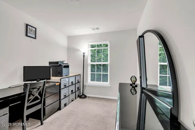 a view of a workspace with furniture and a window