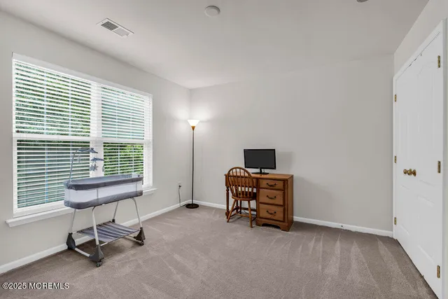 a view of a workspace with furniture and a window