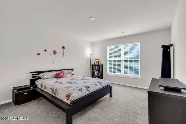 a bedroom with a bed and a dresser in it