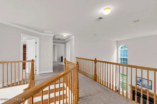 a view of a hallway with wooden floor and windows