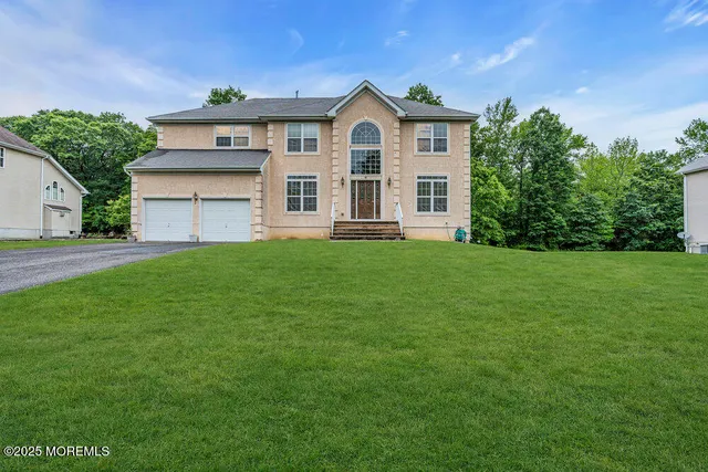 a view of a yard in front of a house with plants and large tree