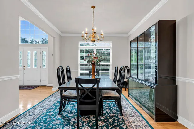 a dining room with furniture a chandelier and wooden floor